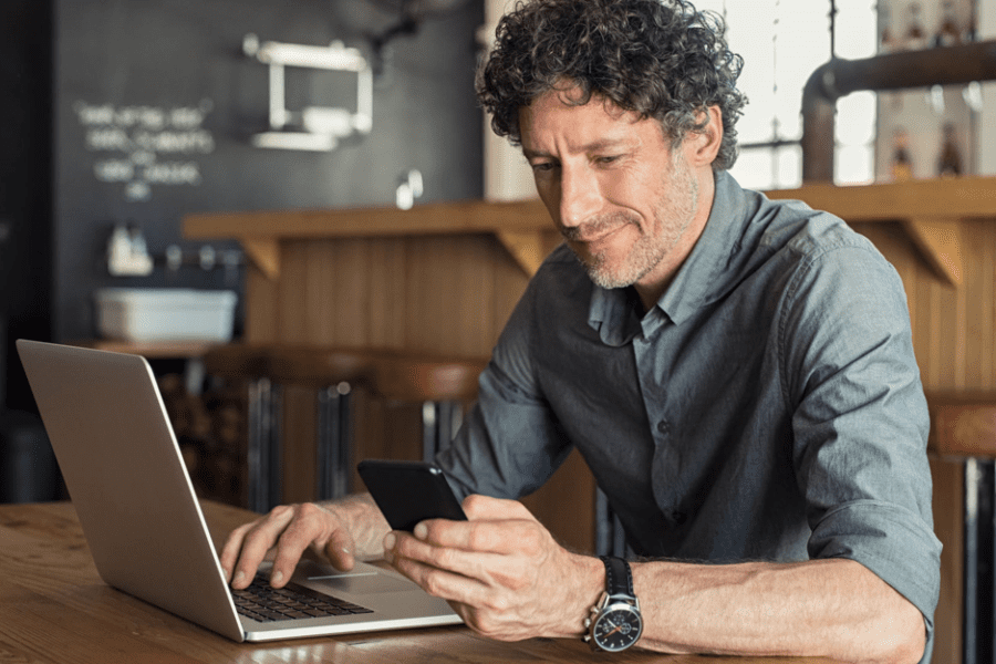Bartercard member texting on smart phone while answering emails