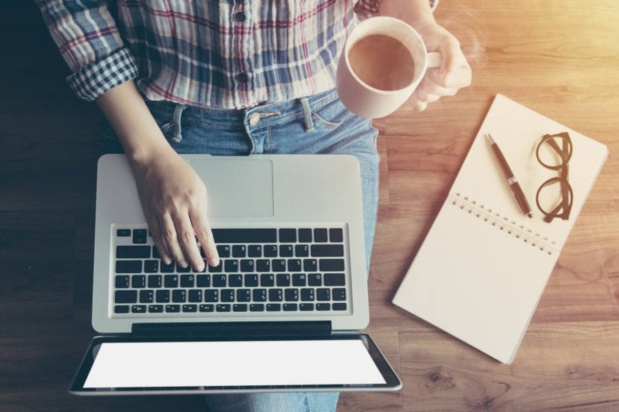 Woman working with notebook and laptop computer, writing content to get more customers