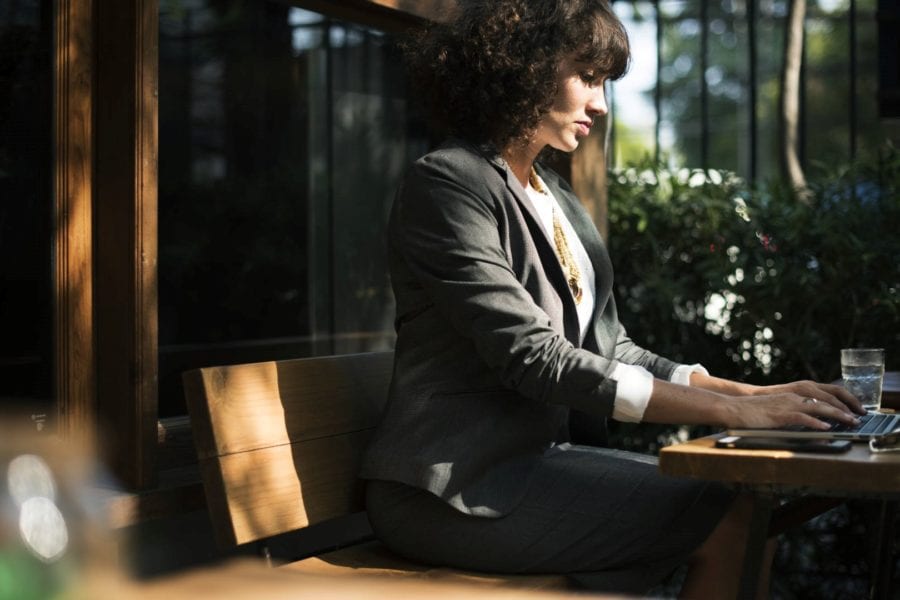 Businesswoman explores Bartercard network on laptop outdoors