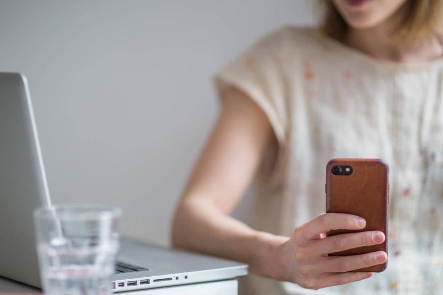 Woman working from home, using technology to maintain business network