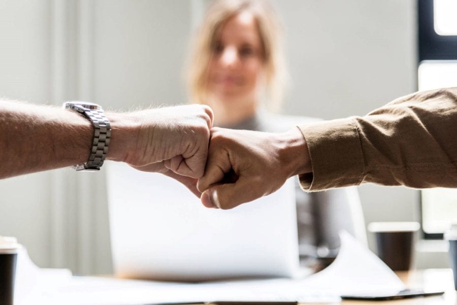 Two businesspeople fist bump during successful business recovery