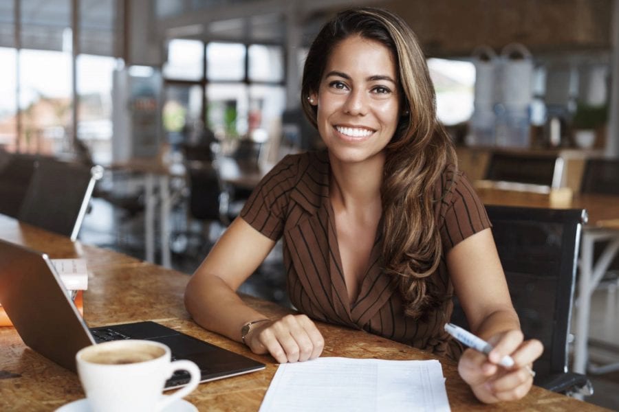 Entrepreneur sitting alone in café with opened laptop, developing business plan