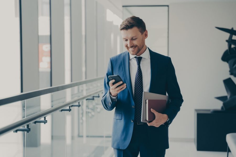 Businessman checking his mobile, exploring the best marketing blogs online
