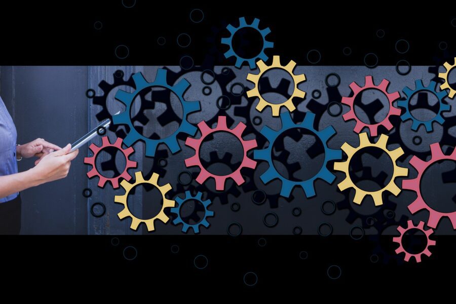 Business woman holding a tablet with an image of cogs working together