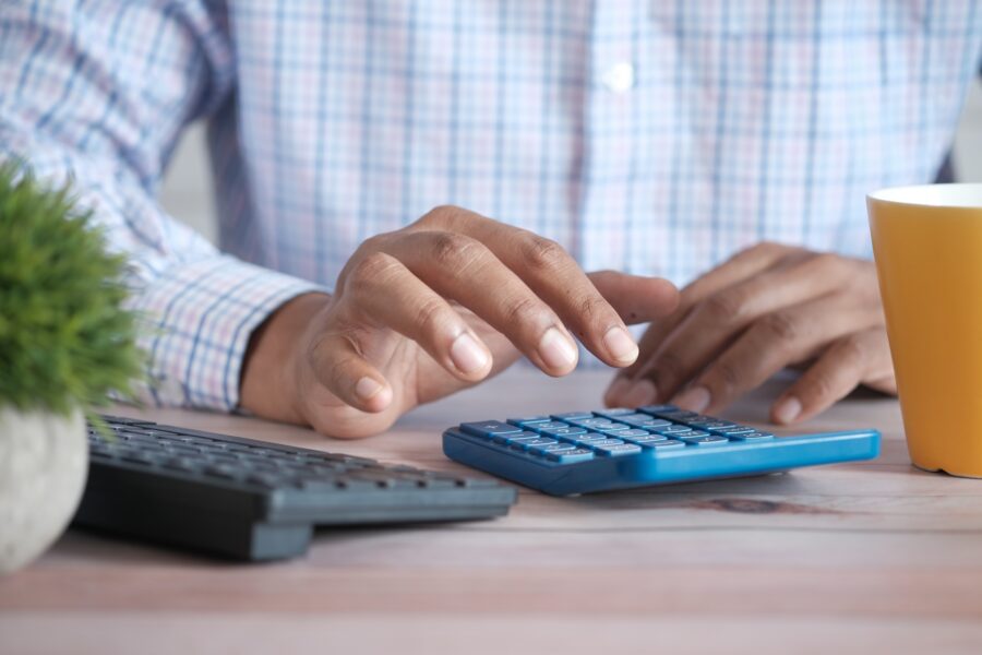 Close-up of a man's hand using a calculator