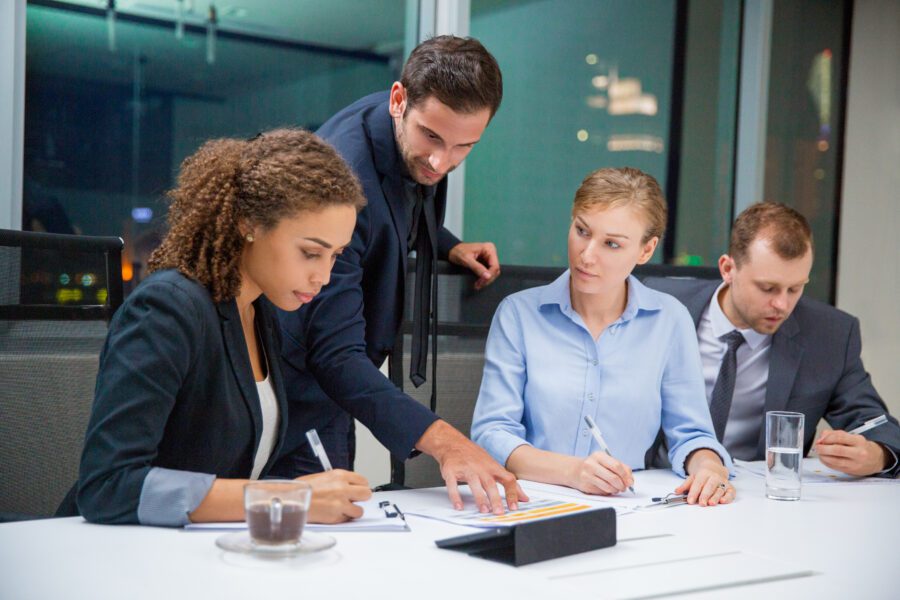 Man in suit showing two partners a paper