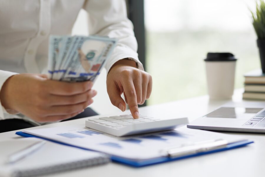 Female accountant holding cash banknotes counting money.