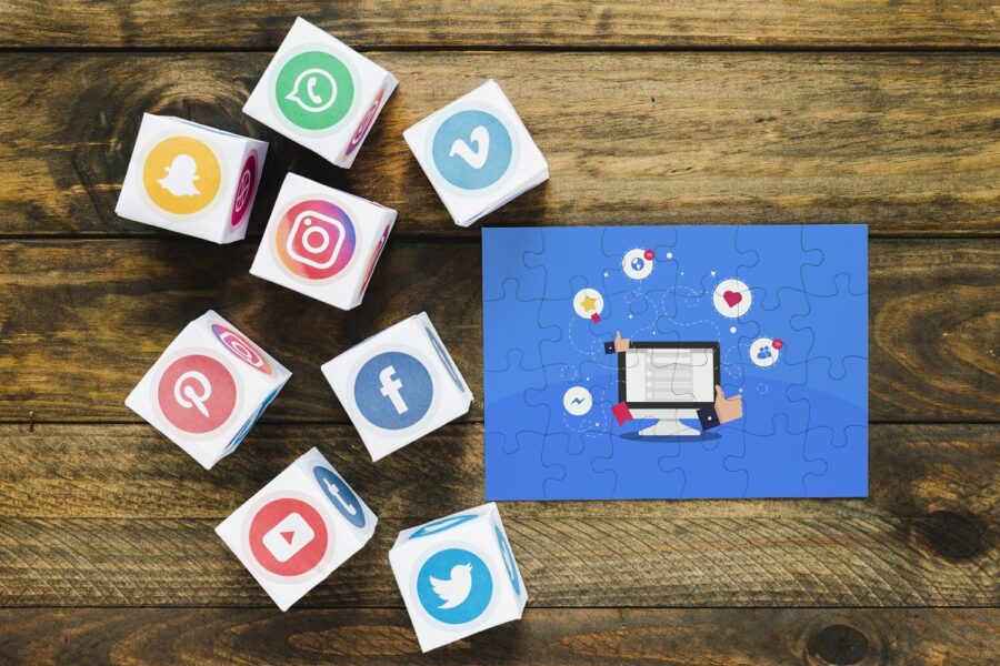 A group of cubes with social media logos on them next to a jigsaw puzzle